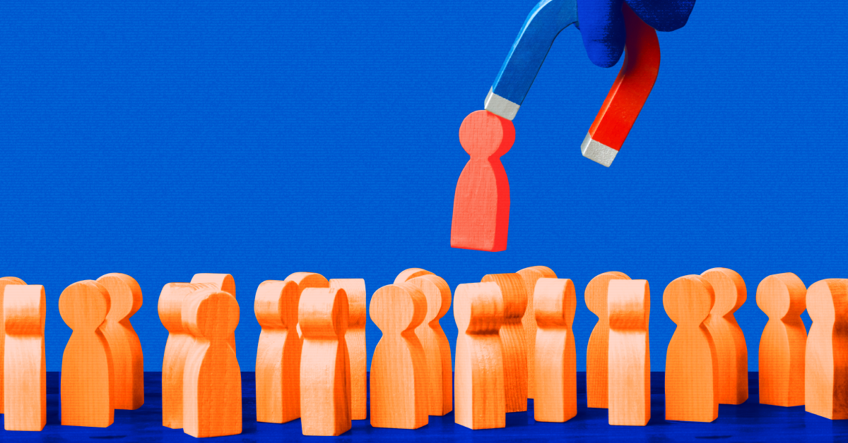 Orange wooden human figures spread out on a blue floor and against a blue background with one red human figure pulled out but a blue and red magnet. 
