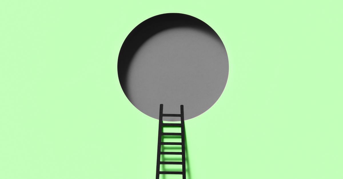 A black ladder going into a gray open circle on a green background. 